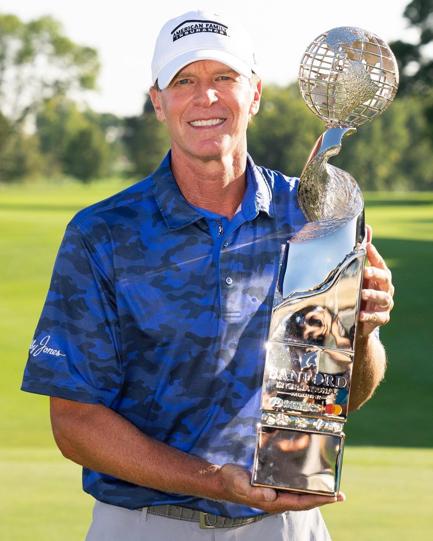 Sanford International Champion Steve Stricker holding redesigned trophy made by Malcolm DeMille